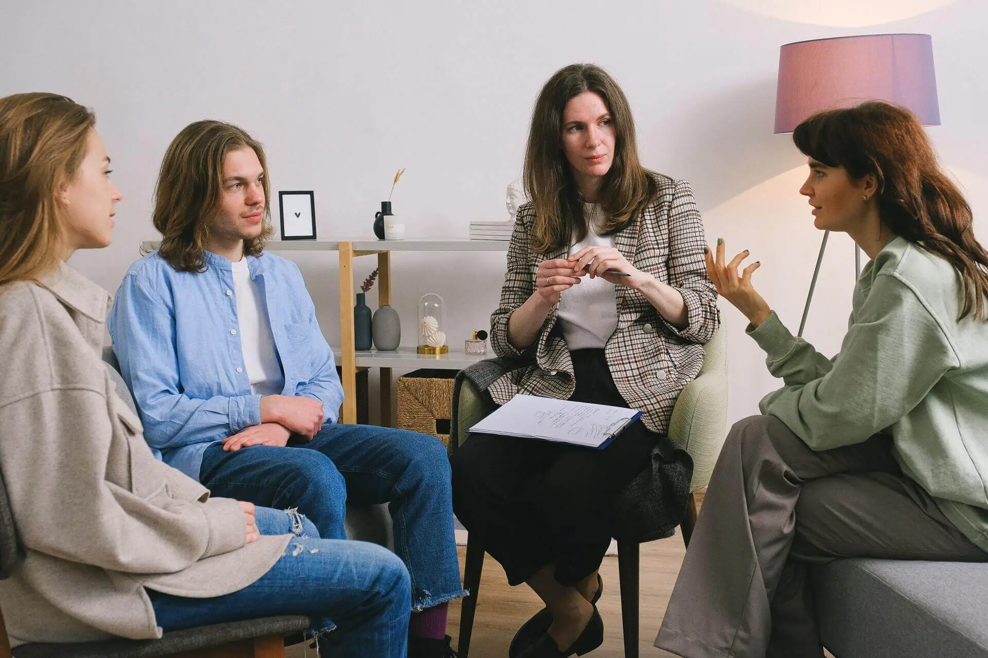 Small group of adults in a facilitated discussion in a softly lit office