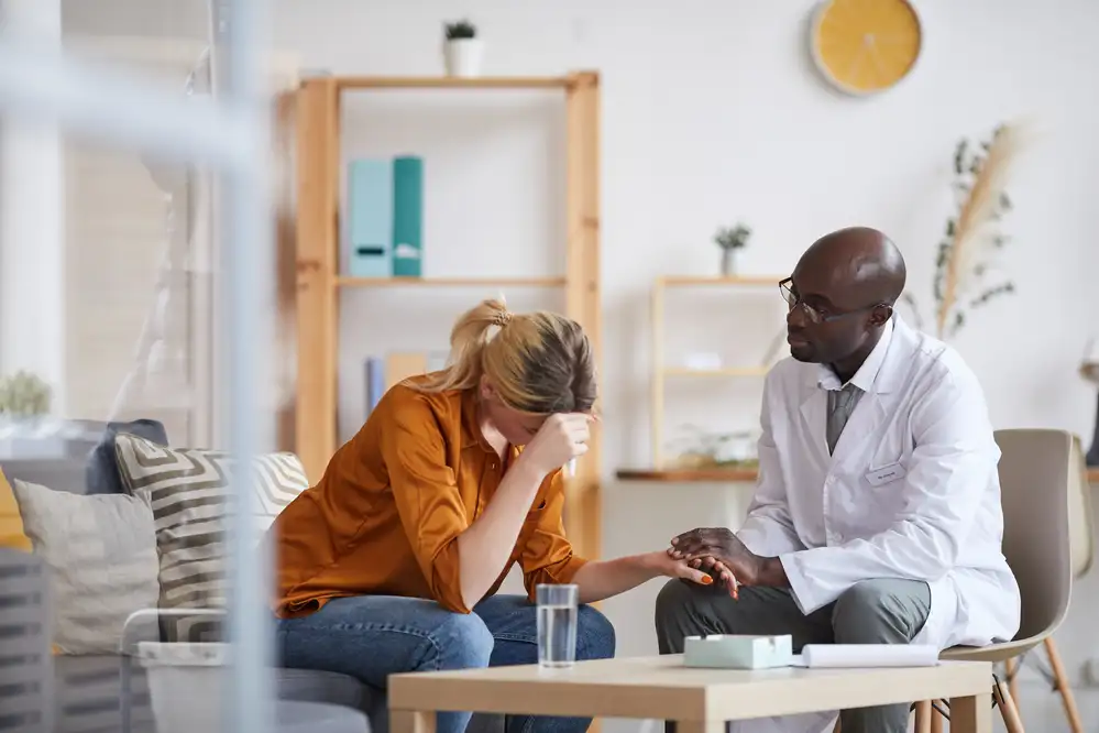 A psychiatric nurse practitioner consulting with a patient about anxiety in a calm, modern office setting