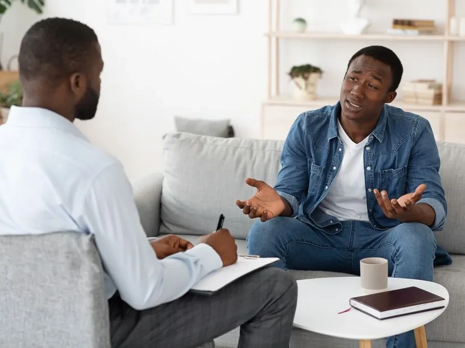 African American woman talking with a therapist during a counseling session in a warm office