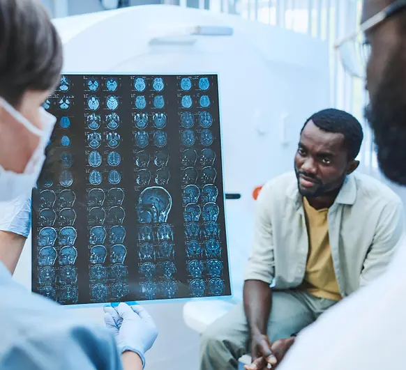 Healthcare provider discussing brain CT scan images with a patient during a TMS consultation