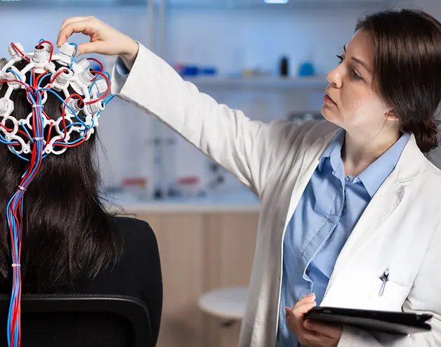 Healthcare provider in white coat holding a neurological model showing brain anatomy and nerve pathways while consulting with a patient