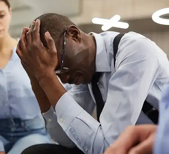 Man in distress holding his head during a depression disorder consultation