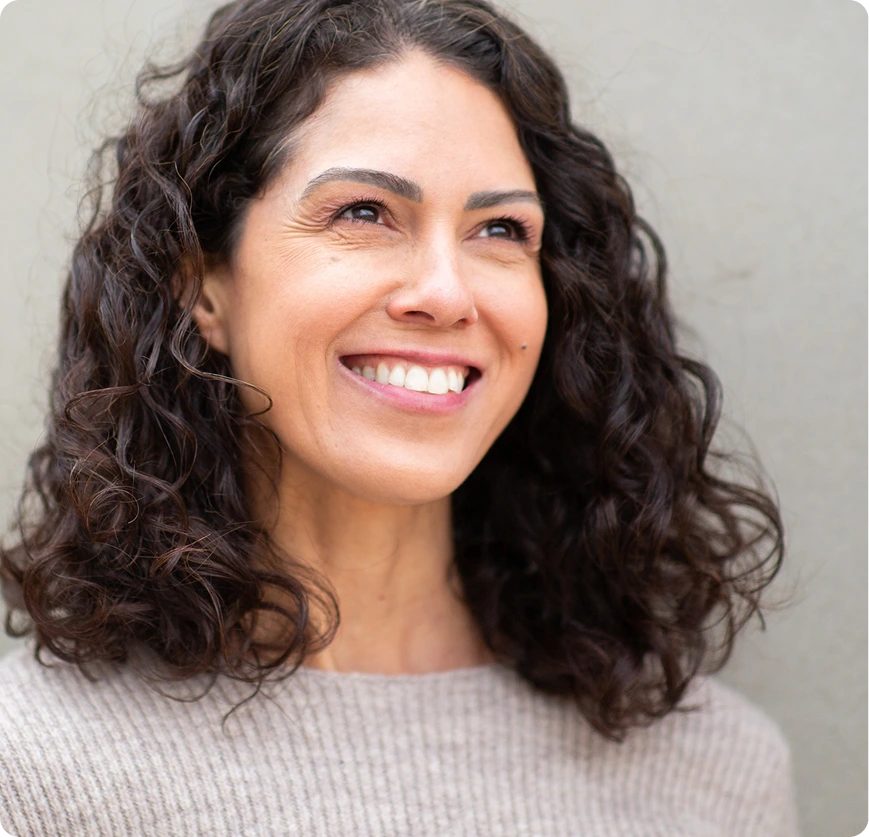 Woman smiling at the camera against a neutral background