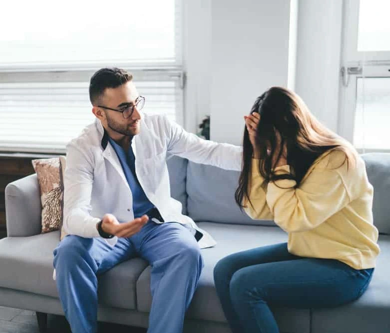Psychiatric nurse practitioner consulting with a patient about anxiety and panic treatment in a bright clinical office