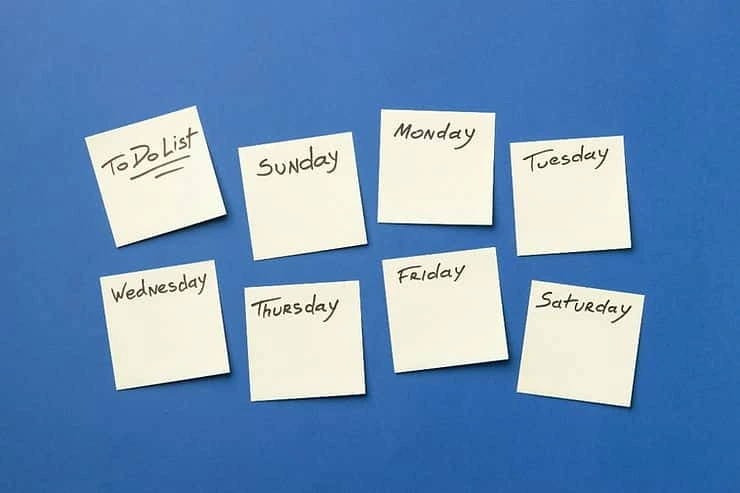 Weekly planning sticky notes labeled with days of the week and a to-do list on a blue background