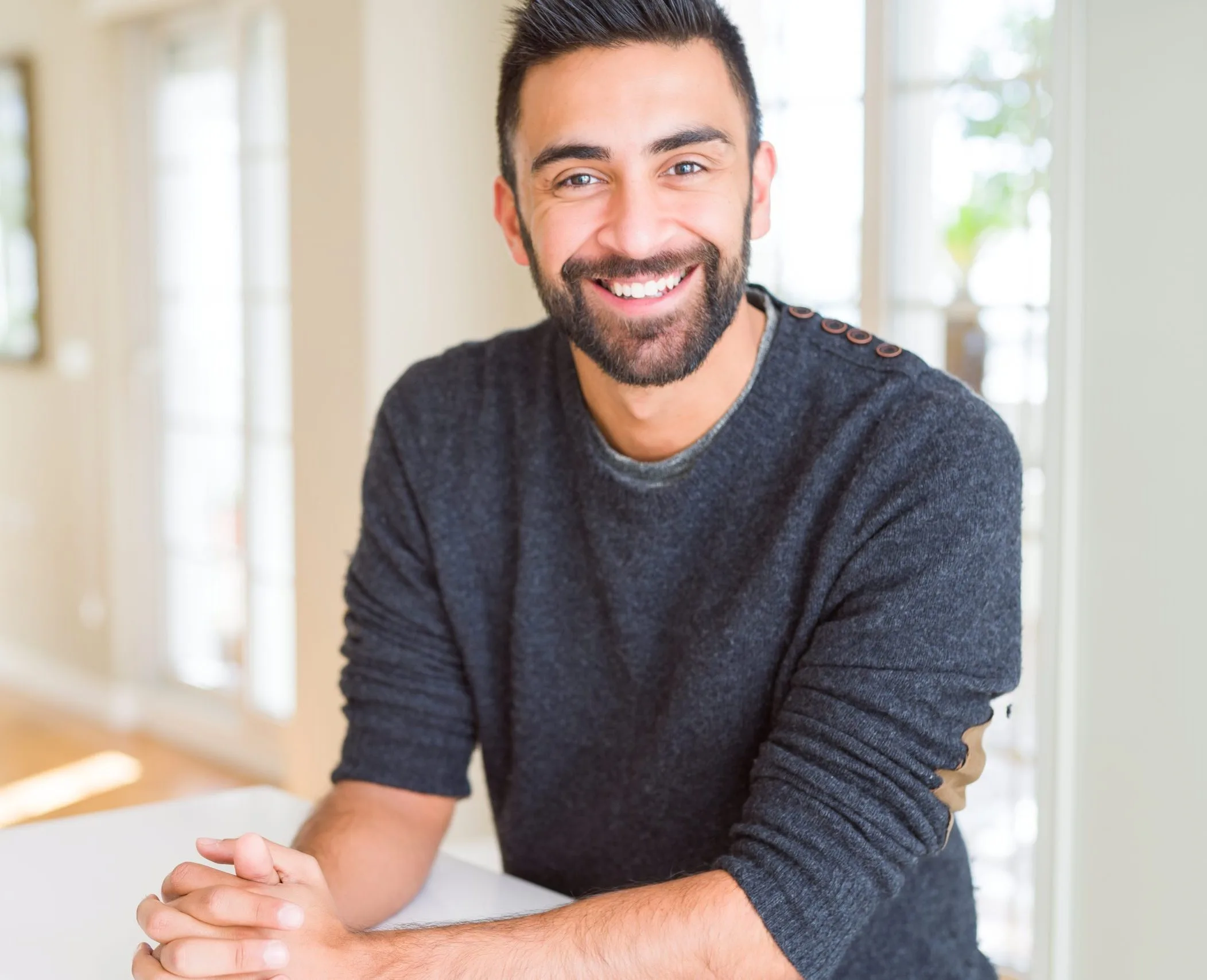 Man smiling broadly in a bright interior space