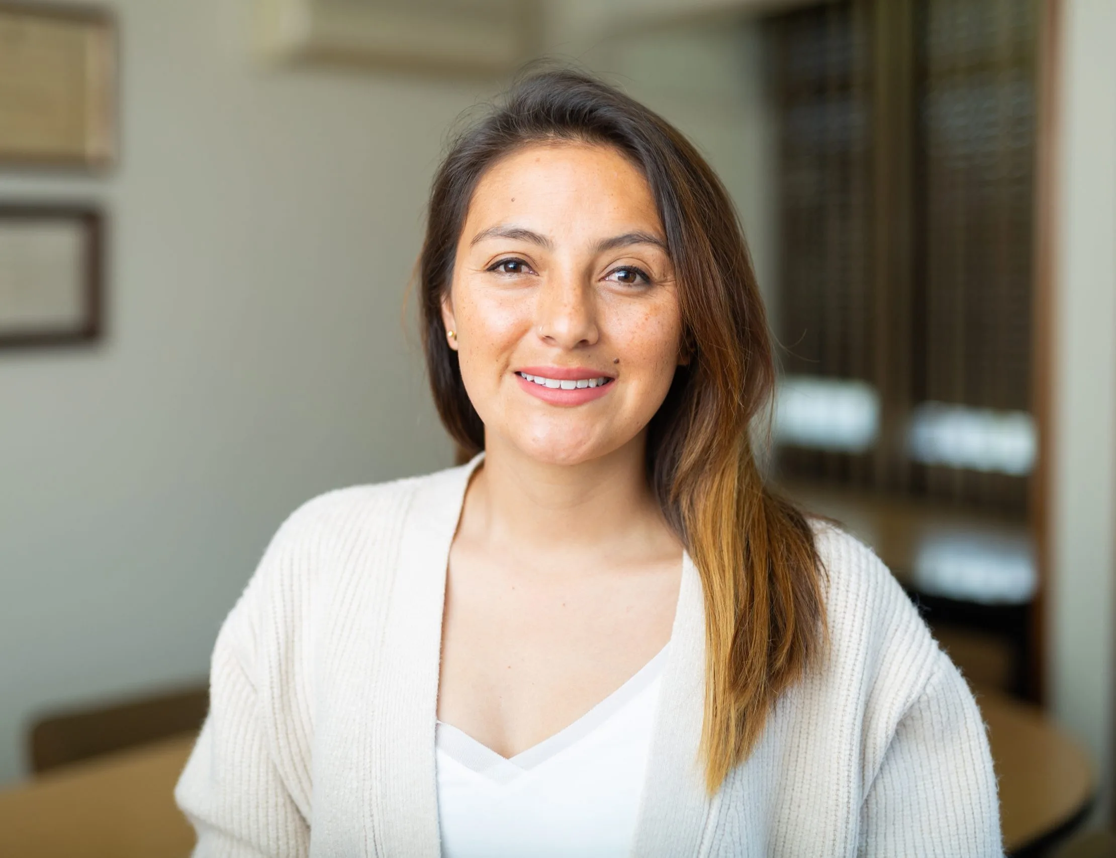 Smiling woman in a light cardigan in a clinical setting