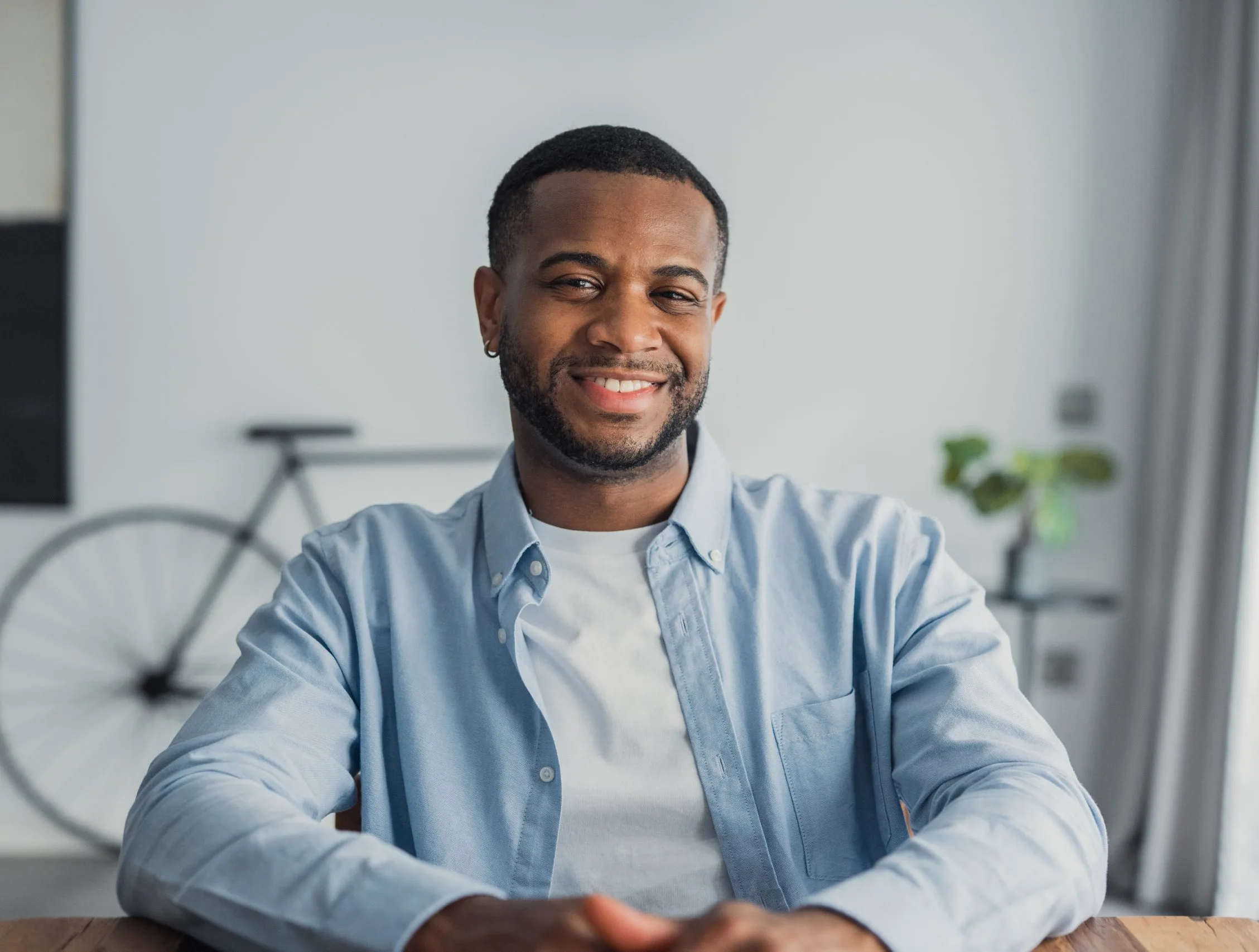 Smiling man in eyeglasses and blue shirt in a modern office setting