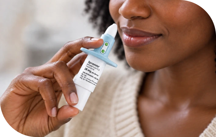 Patient holding a Spravato® nasal spray device near their face