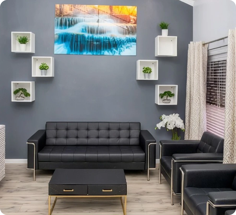 Modern waiting room with gray walls, black leather sofa, potted plants in white shelves, and blue frozen waterfall artwork