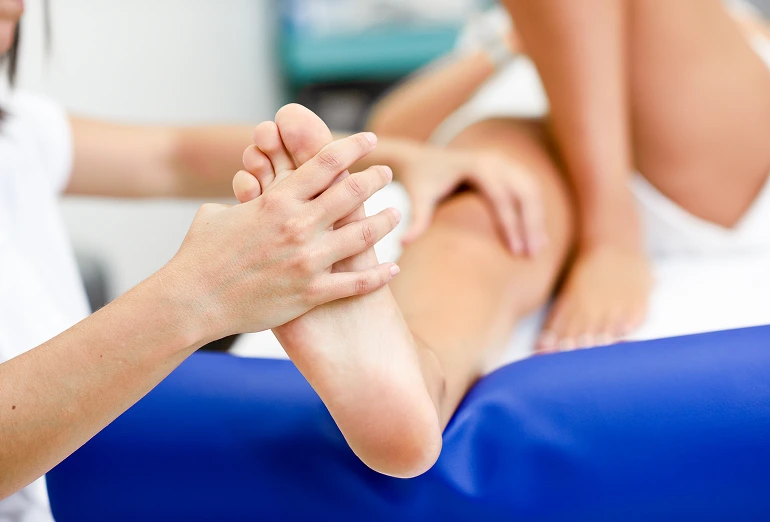 Clinician examining a patient's foot during a neuropathy consultation