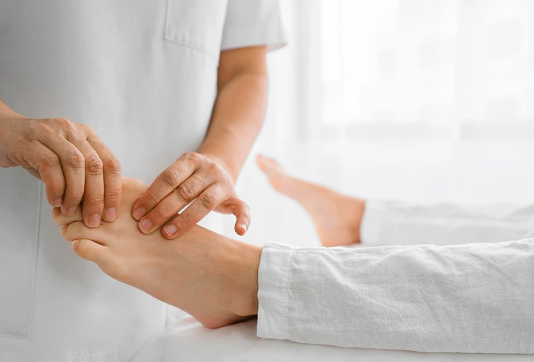 Healthcare provider examining a patient's foot and ankle during consultation