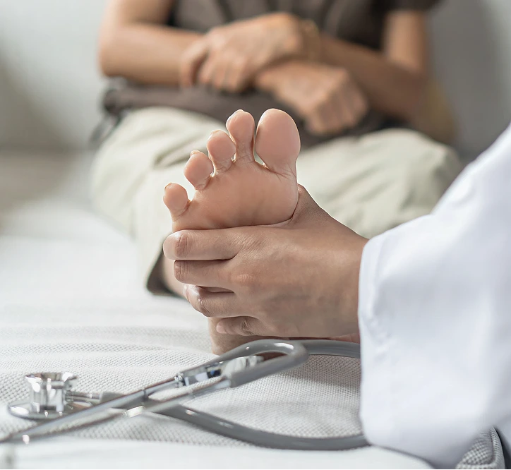 Pediatrician examining infant's foot with stethoscope nearby
