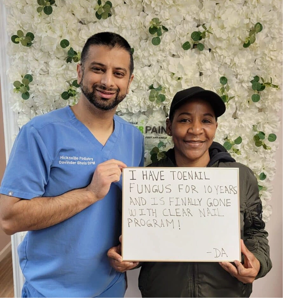 Dr. Davinder Bhela and patient holding sign stating toenail fungus cleared with Clear Nail Program