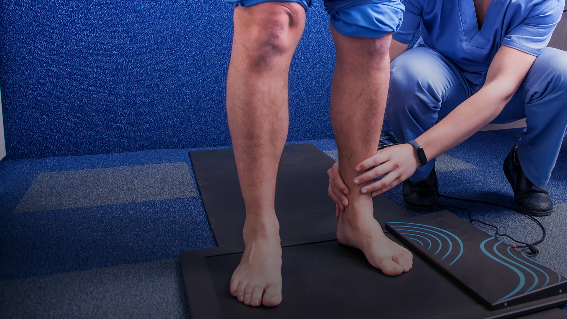 Podiatrist examining patient's foot and ankle while patient sits on examination table