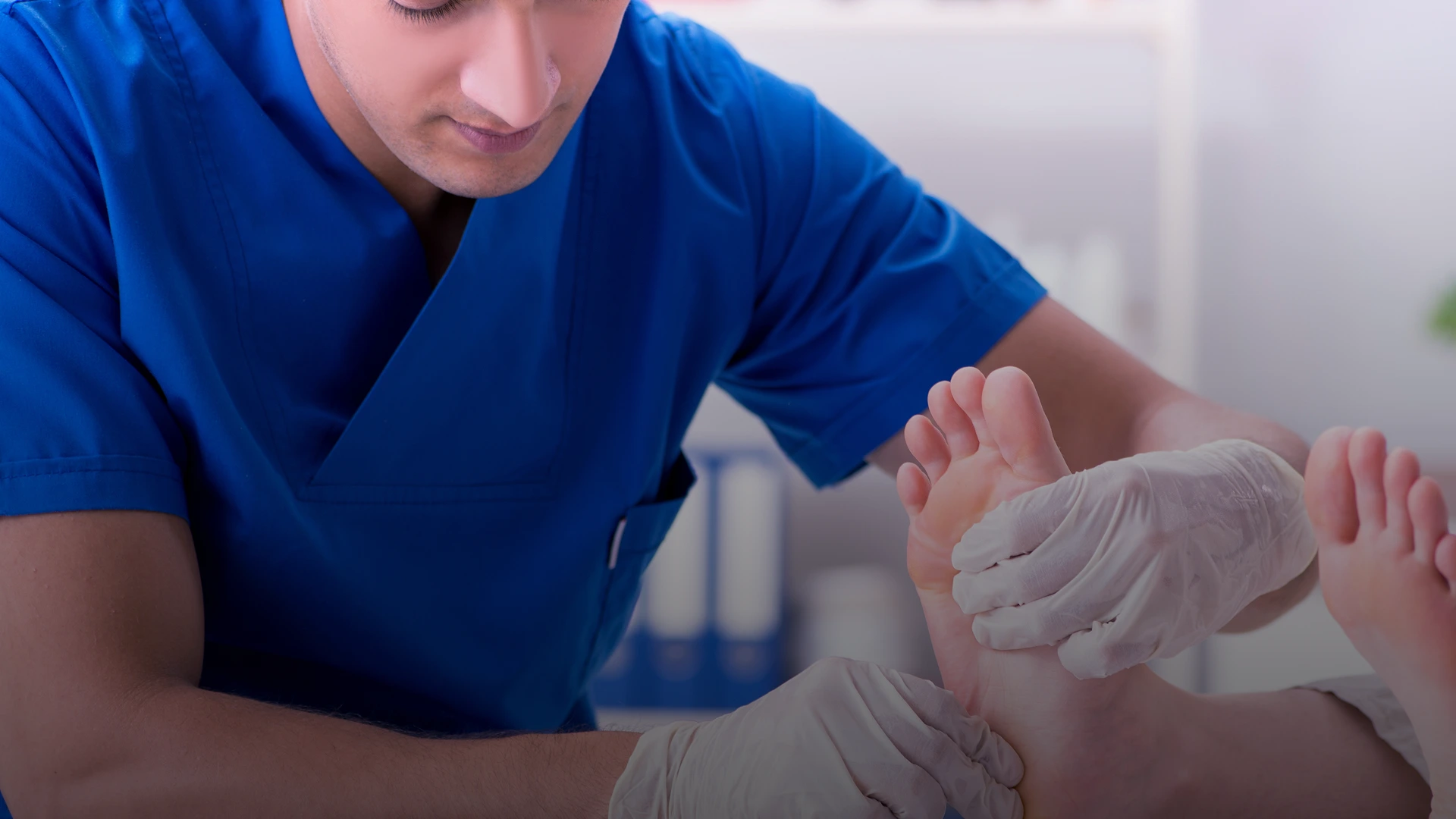 Podiatrist in blue gloves examining a patient's foot during examination