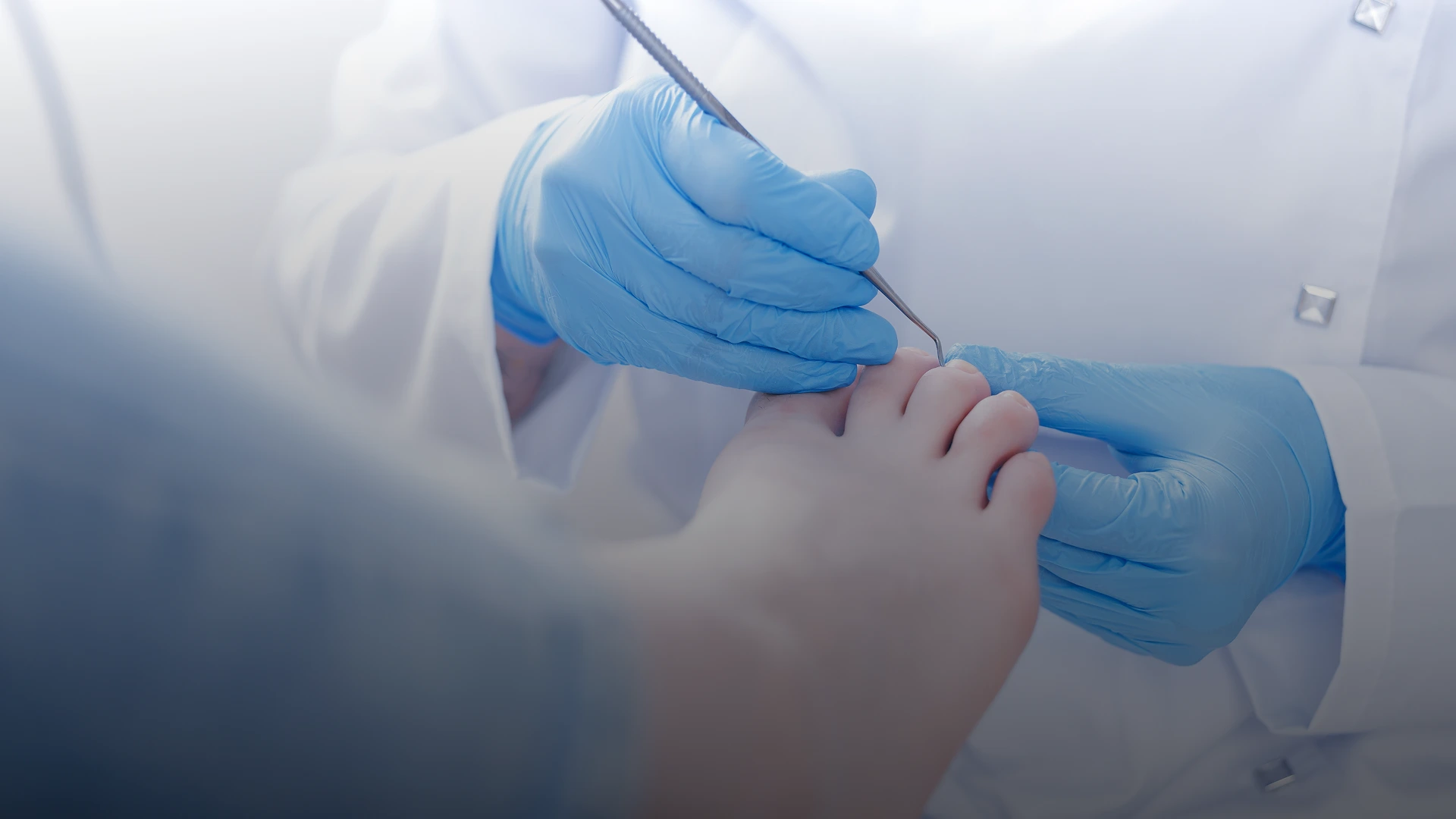 Podiatrist's gloved hands palpating a patient's foot during examination