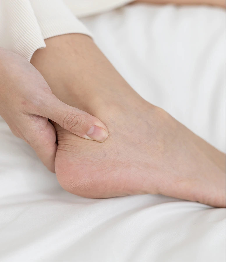 Clinician palpating patient's ankle and foot during examination