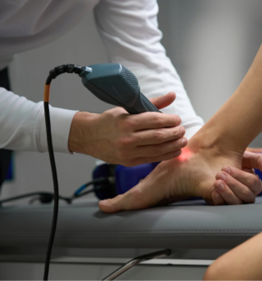 Podiatrist holding ultrasound probe over patient's foot during diagnostic imaging