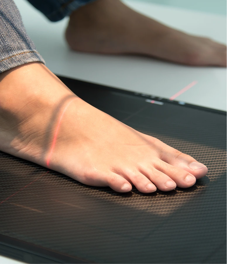Red laser beam being applied to patient's foot during treatment session