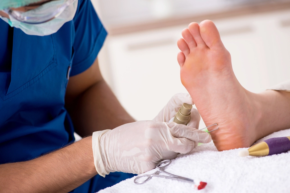 Podiatrist examining patient's foot with diagnostic instrument during clinical evaluation