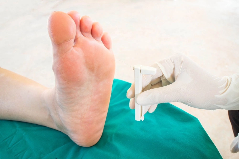 Podiatrist scanning swollen foot with handheld diagnostic ultrasound probe