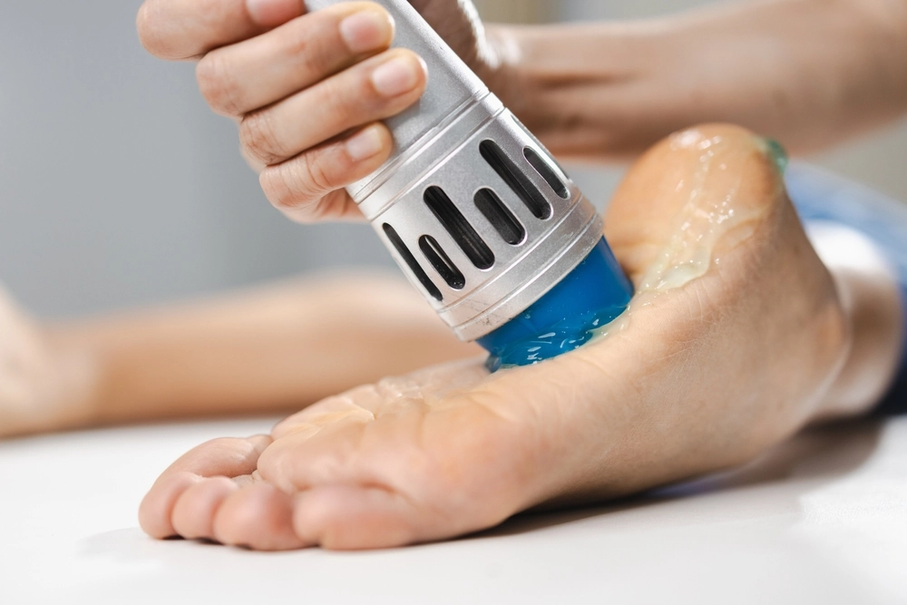 Shockwave therapy device being applied to patient's foot for physical therapy treatment