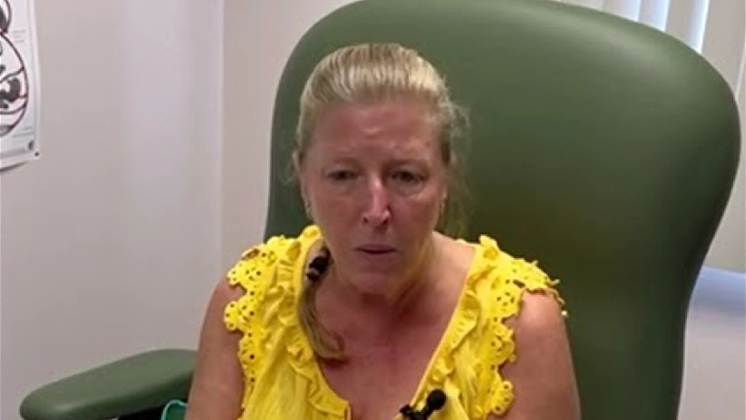 Patient in yellow lace top speaking in podiatry clinic treatment room