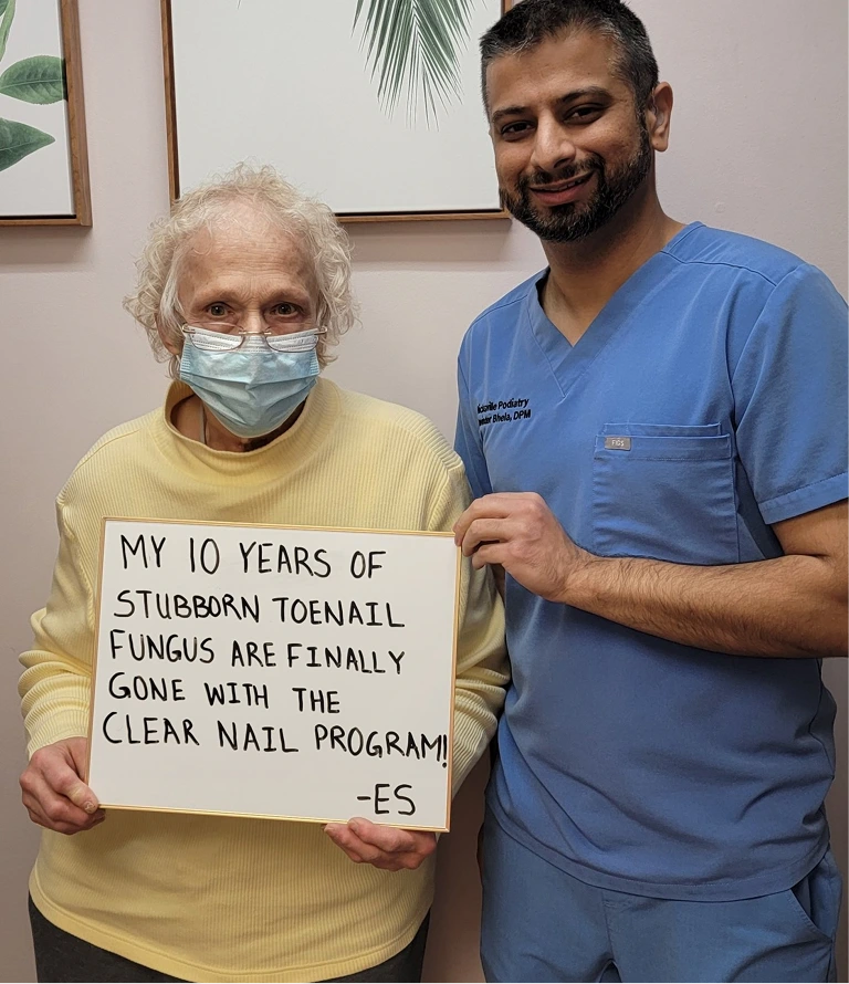 Podiatrist with senior patient wearing mask, holding testimonial about toenail fungus treatment with Clear Nail Program