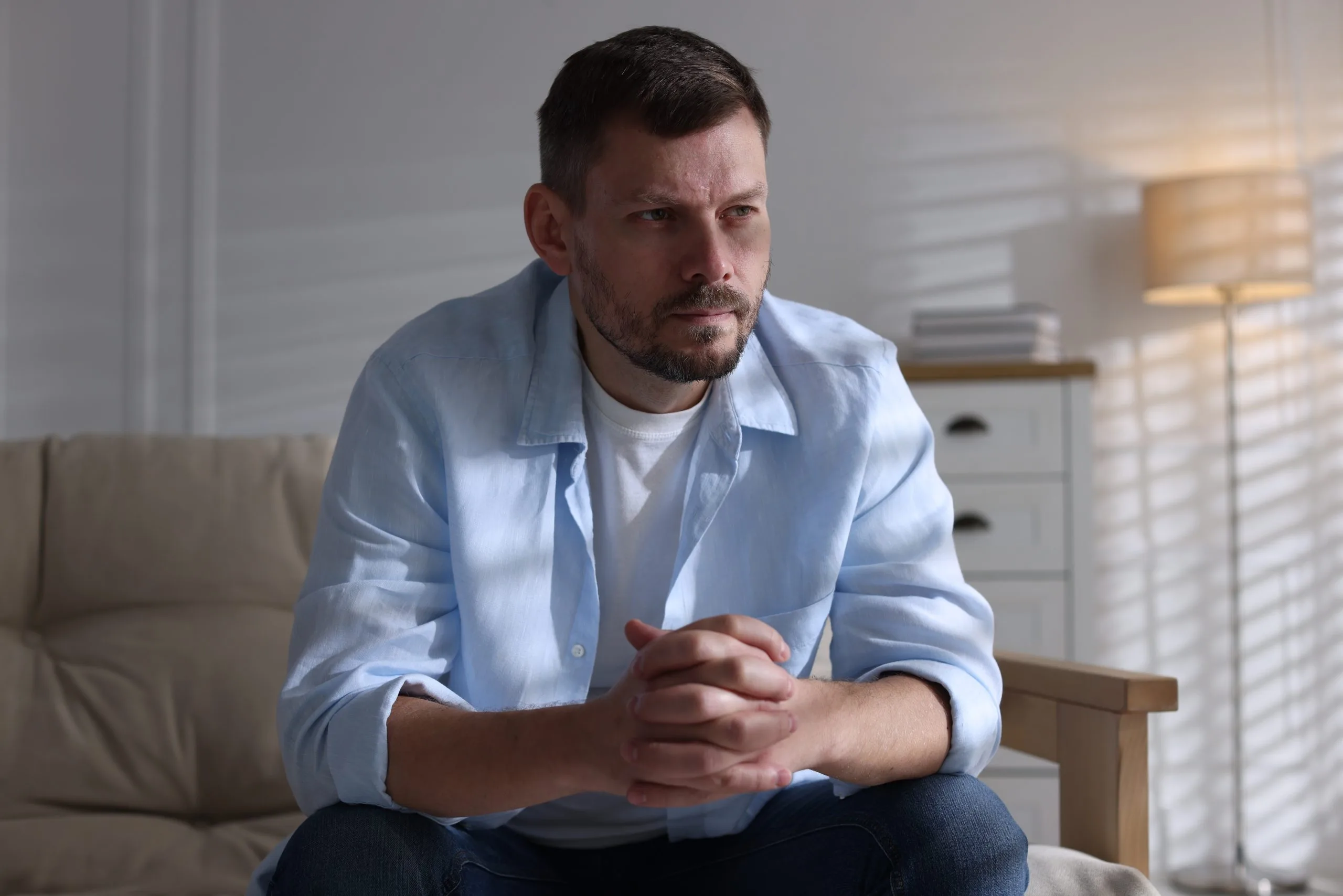 Man on a sofa at home experiencing depression symptoms