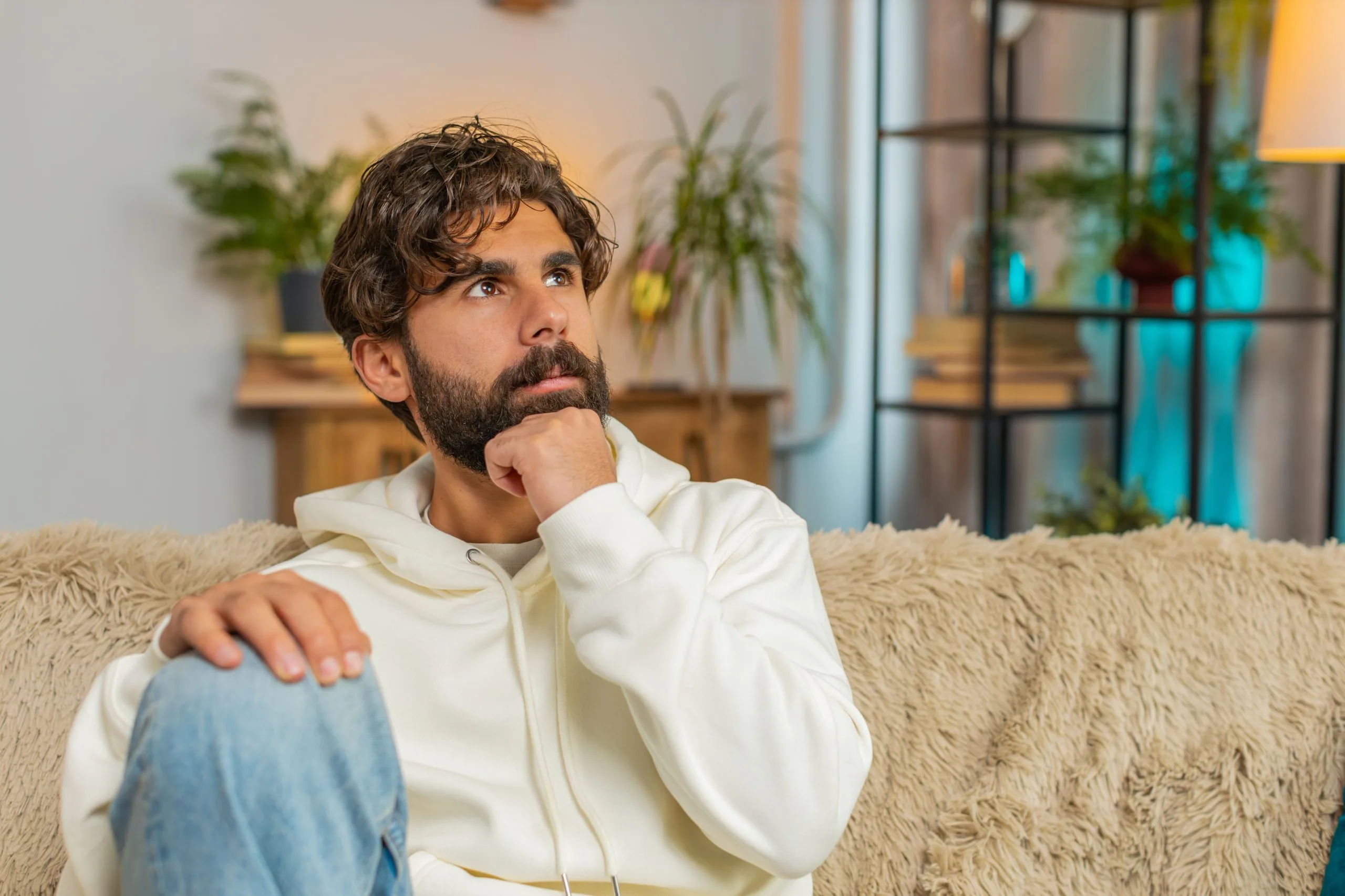Man sitting at home looking pensive before seeking psychiatric care