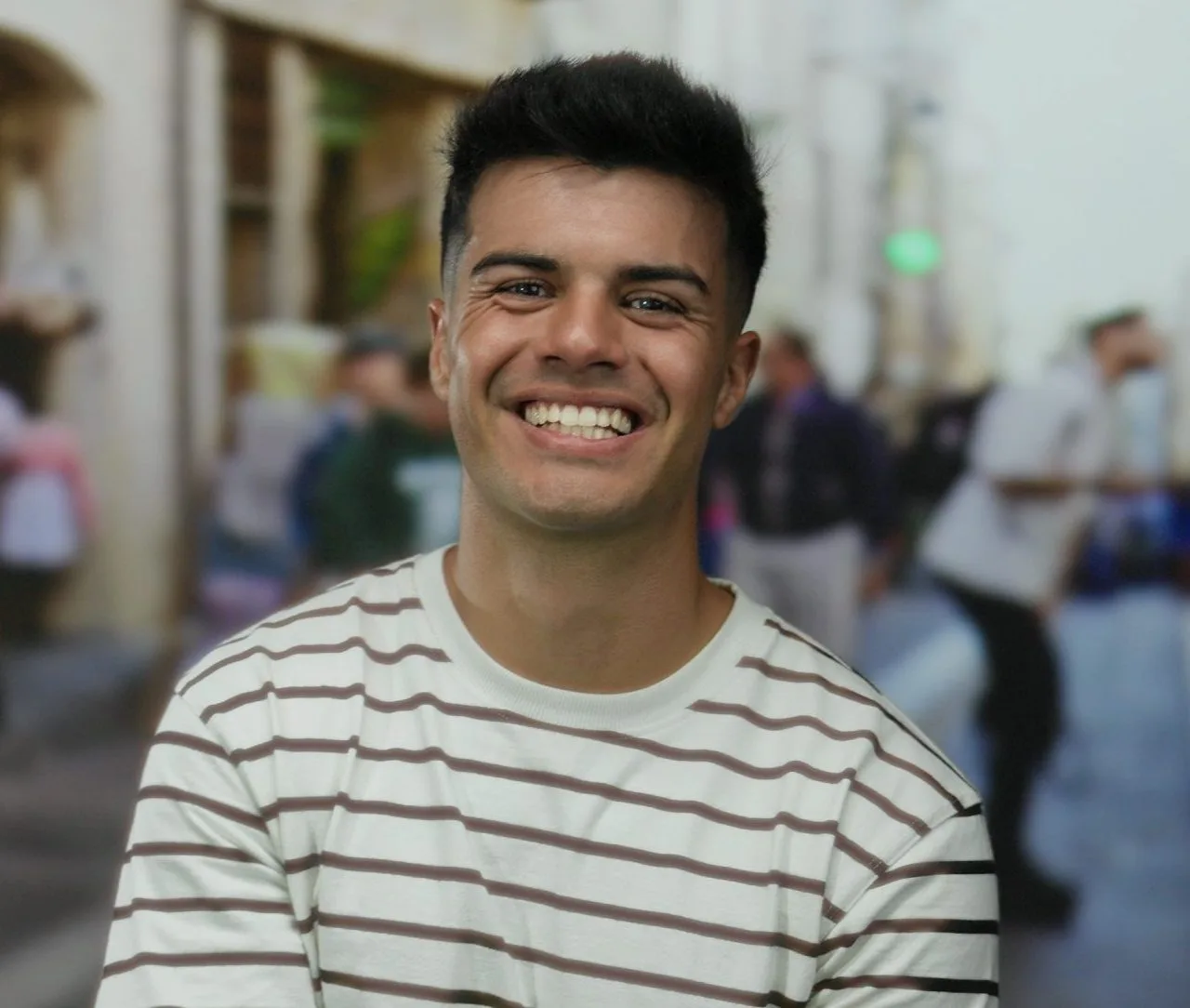 Young man laughing on a city street after psychiatric treatment