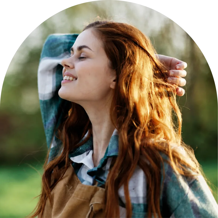Woman smiling outdoors after virtual psychiatric care with Restore Psychiatry and Wellness