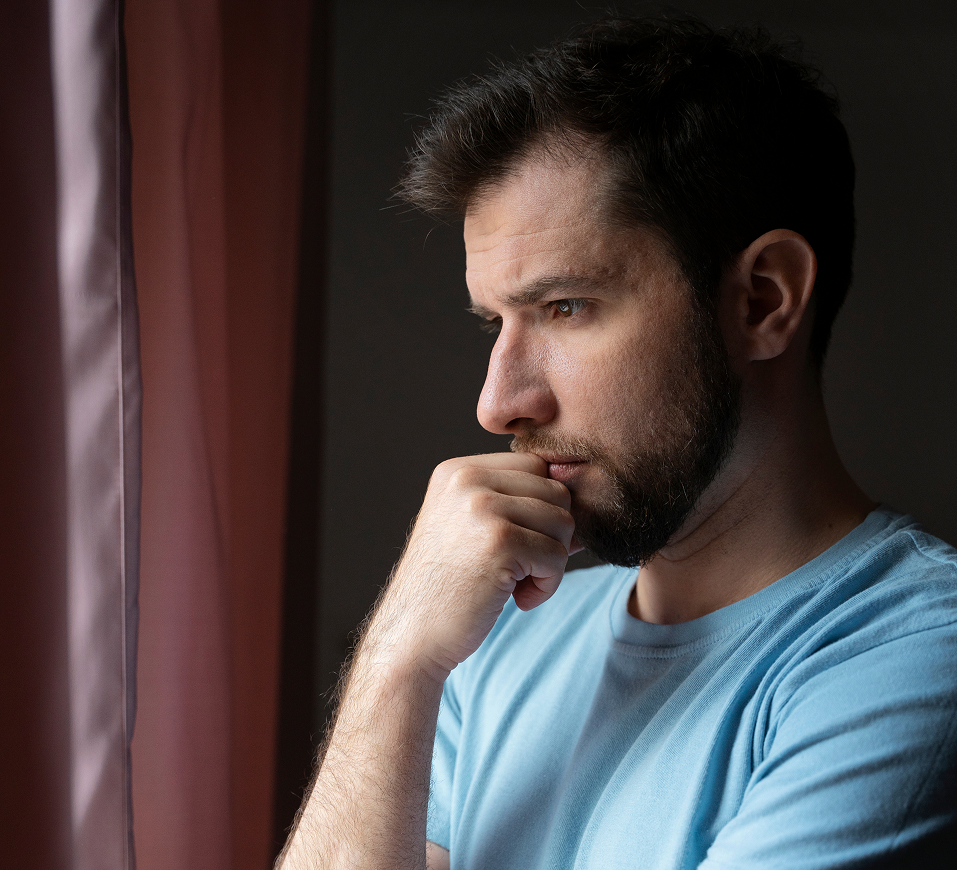 Man with furrowed brow and hand to chin in pensive expression