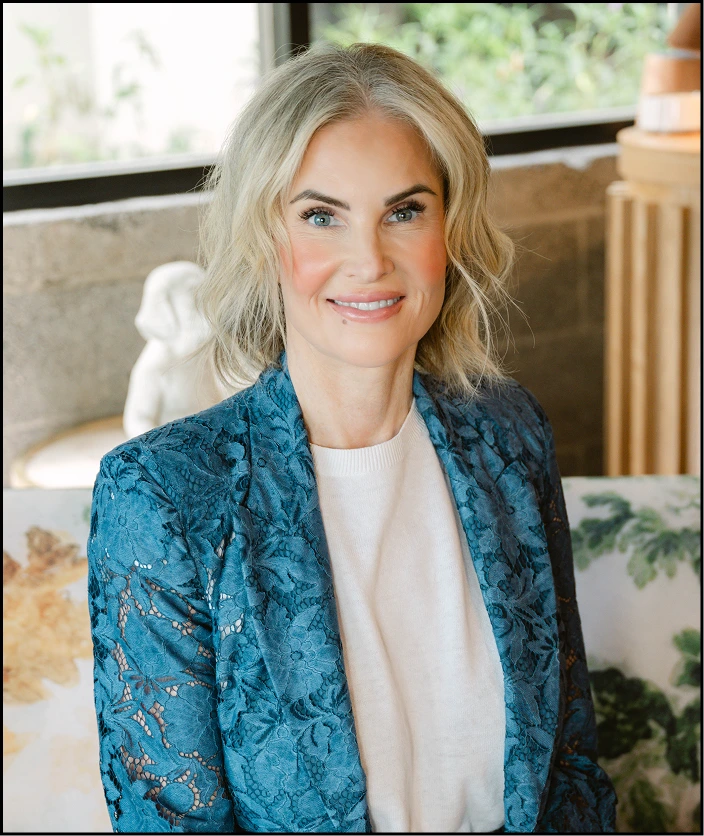 Eric Jones, woman with shoulder-length blonde hair wearing teal patterned blazer