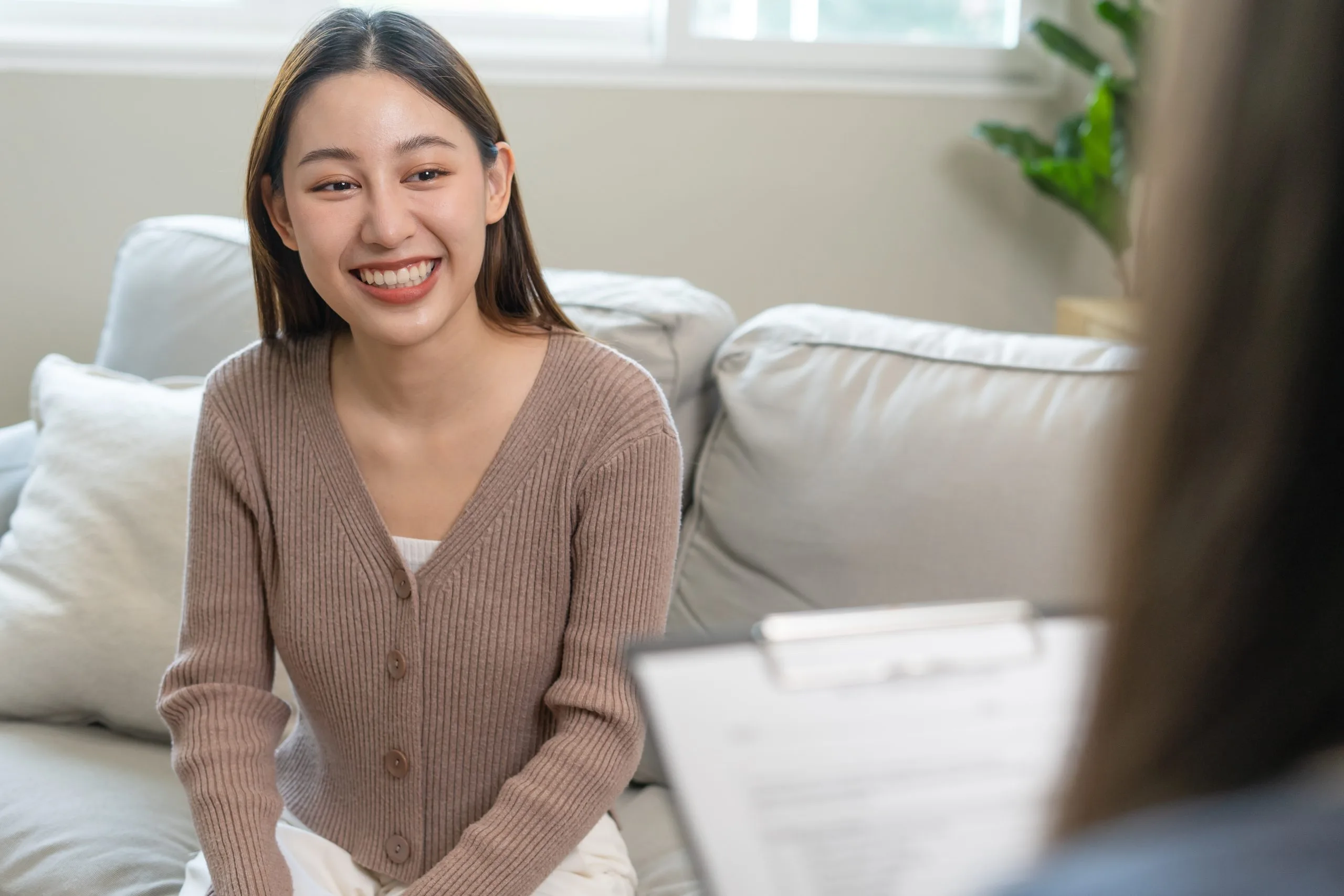 Smiling woman on couch engaged in conversation during therapy session
