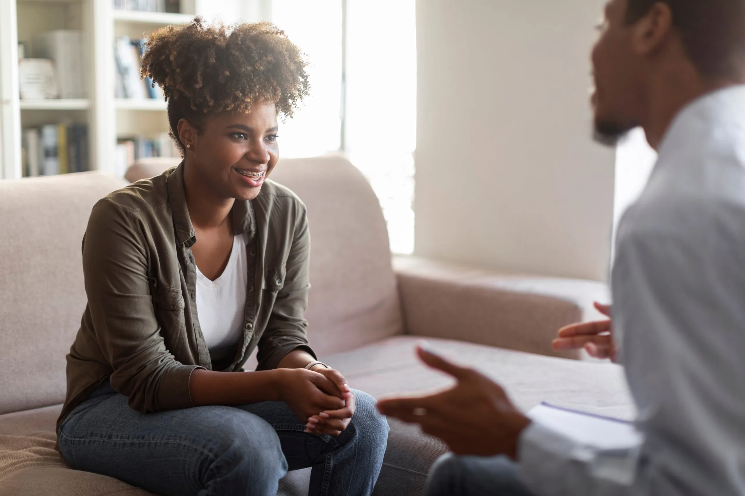 Woman smiling during therapy session with male clinician in office setting