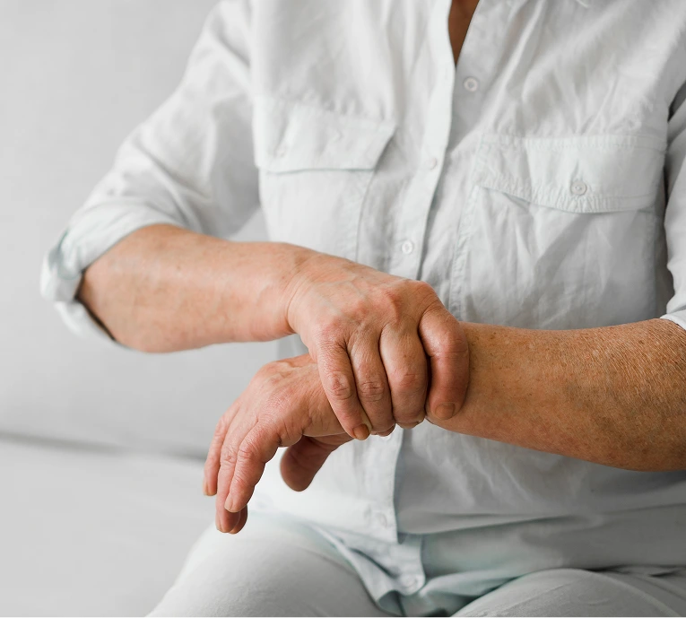 Healthcare provider in white coat palpating a patient's wrist and forearm during examination