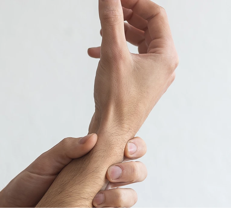 Person's hand palpating another person's forearm and wrist