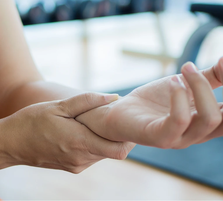 Adult hand gently supporting infant's hand during examination