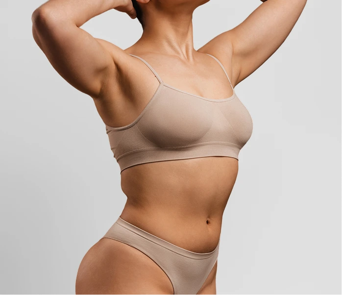 Person with arms raised showing toned back, shoulders, and defined abdominal area
