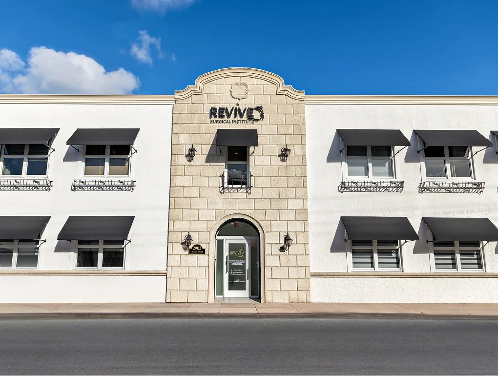 Revive Surgical Institute exterior storefront with stone and white facade under clear sky
