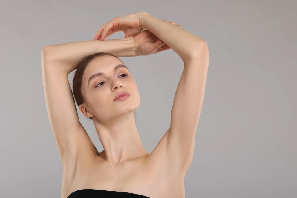 Woman displaying smooth skin on her arm and underarm after laser hair removal
