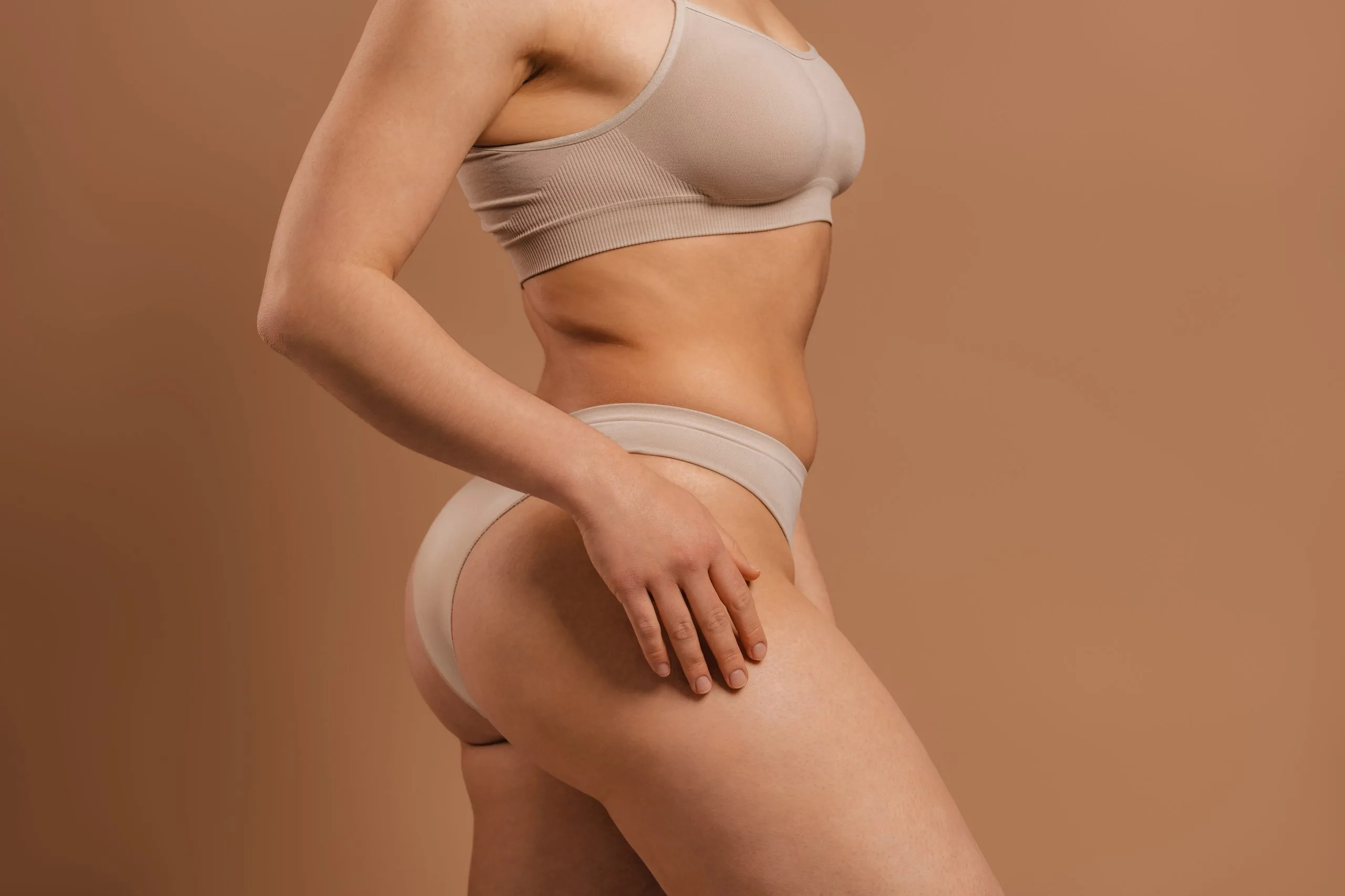 Side profile of a woman's abdomen, hips and buttocks, areas addressed in a mommy makeover
