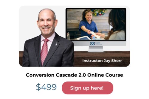 Man in suit and maroon tie next to monitor showing instructor Jay Shorr teaching, promoting Conversion Cascade 2.0 Online Course for $499