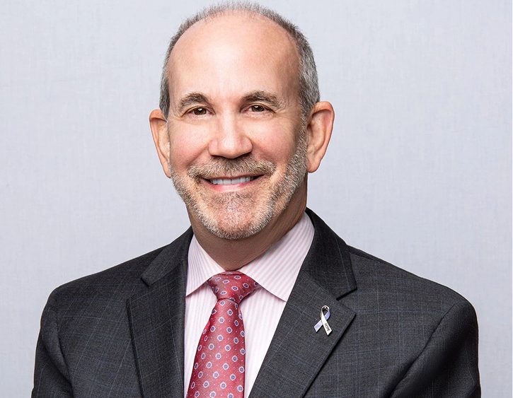 Jay Shorr, professional headshot wearing charcoal suit with pink shirt and red patterned tie