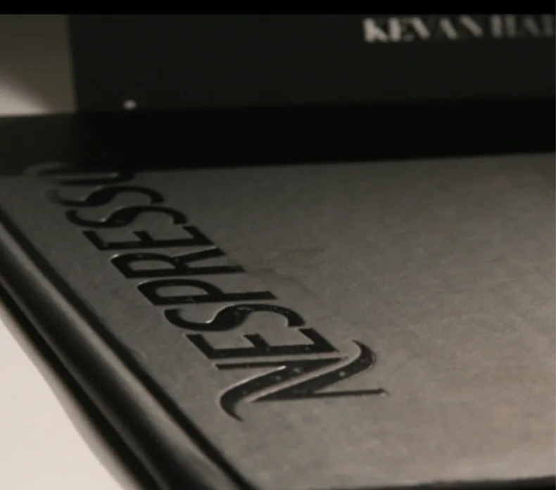 Embossed black portfolio or branding material with raised letter design detail