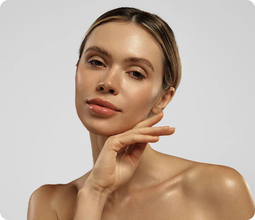 Woman with hand to chin displaying clear, glowing skin
