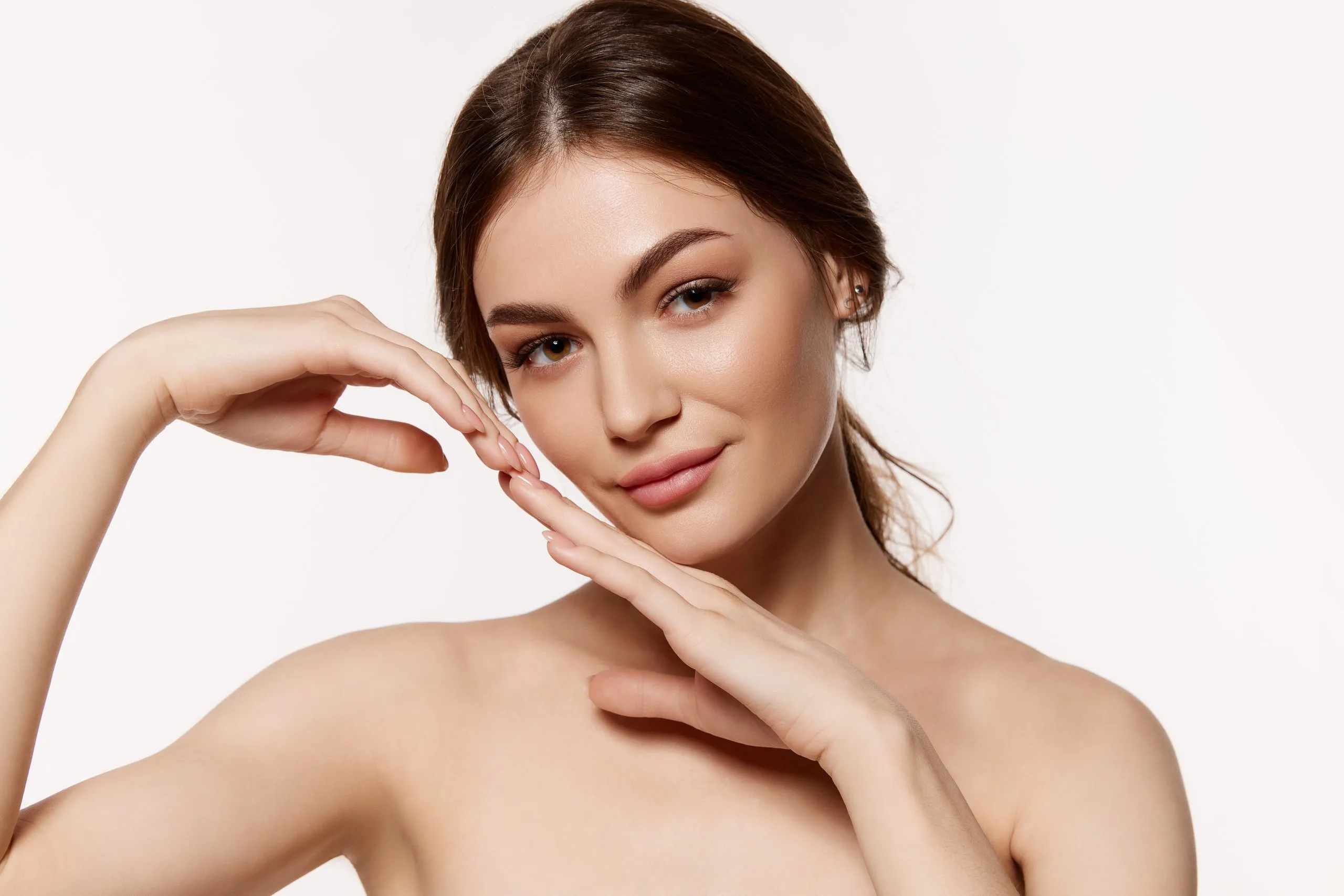 Woman with smooth skin touching her face and shoulder