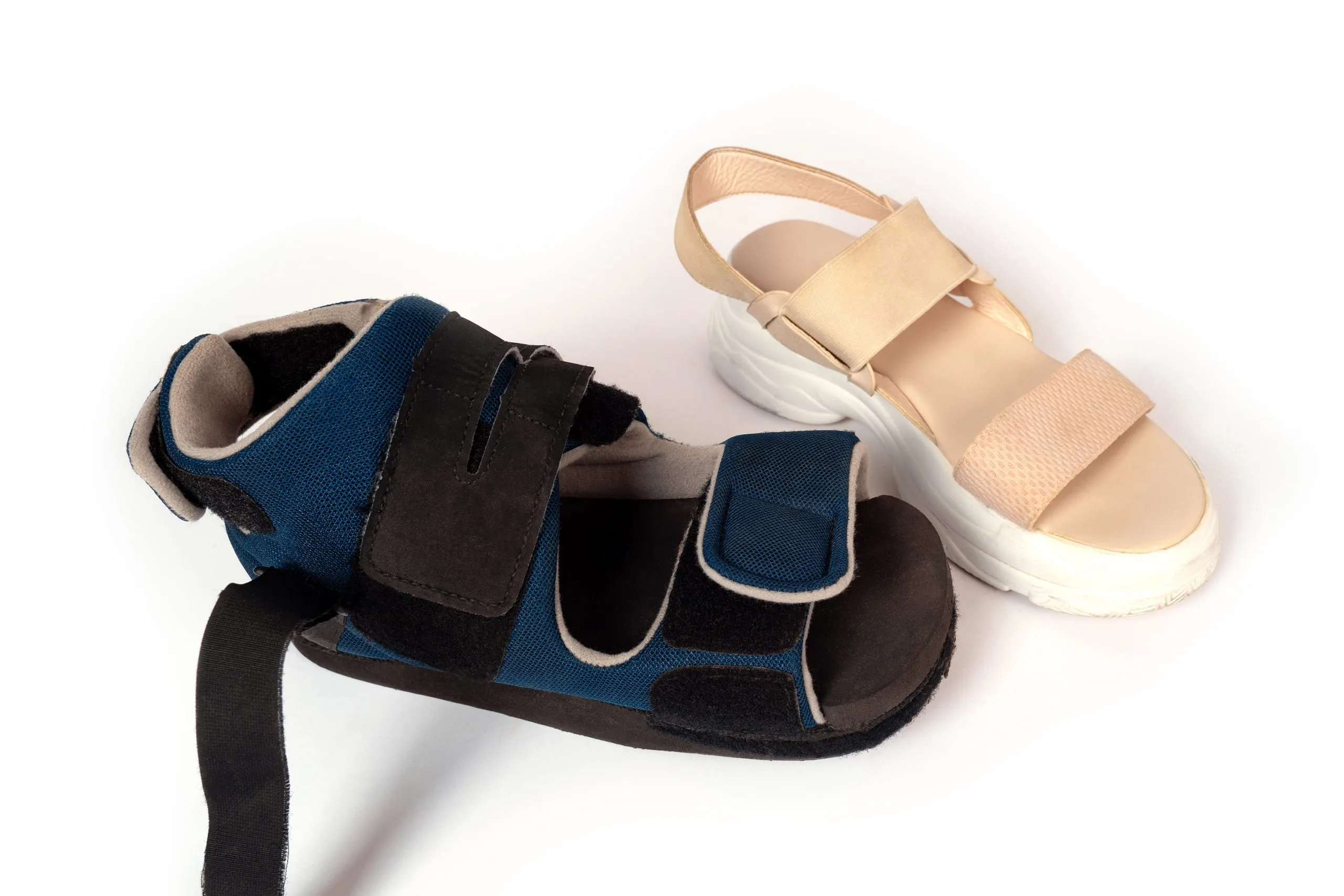 Protective footwear options including a blue and black post-operative sandal and beige strappy sandal
